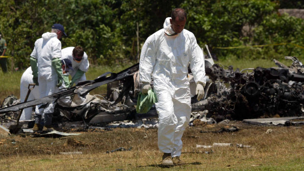 Naval medical officers work through the wreckage of the Australian Navy Sea King helicopter