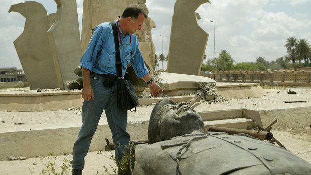 Paul McGeough looks down at one of the many felled Saddam Hussein statues in Baghdad during the 2003 invasion.