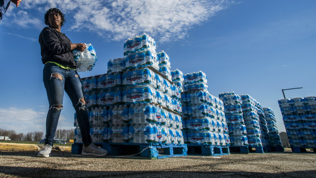 Volunteers load cases of water into vehicles in Flint, Michigan, in April.