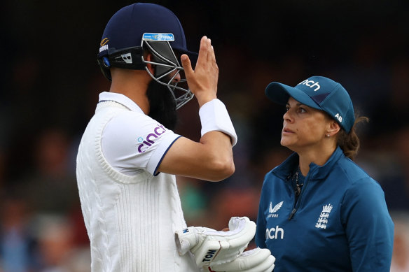 Moeen Ali is checked after being hit on the helmet.