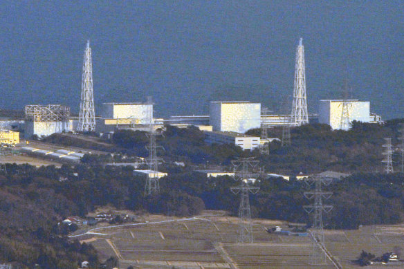 Unit 1 reactor, left, of the Fukushima Daiichi nuclear power plant with its top walls blown off in 2011.