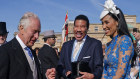 King Charles III speaks to Lionel Richie and Lisa Parigi during the Garden Party at Buckingham Palace ahead his coronation on Saturday. 