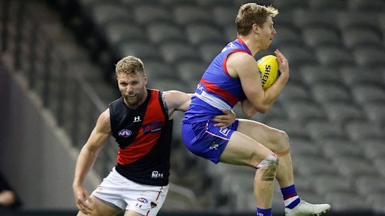 Bulldog Lachie Hunter, right, competes against Essendon’s Jake Stringer.