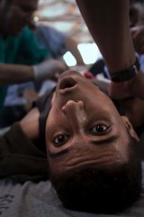 An injured Palestinian youth receives treatment in a field clinic after being shot by Israeli troops during a protest in the Gaza Strip in July.