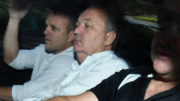 Conman Peter Foster, flanked by police detectives, arriving at court in Brisbane on Thursday.