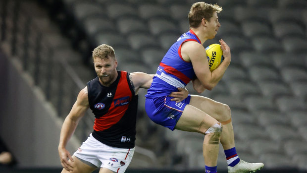 Bulldog Lachie Hunter, right, competes against Essendon’s Jake Stringer.