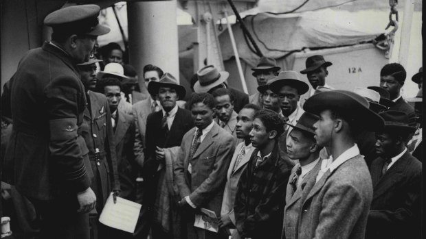 A Royal Air Force recruiting officer speaks to Jamaicans as they arrive in the UK aboard Empire Windrush in June, 1948.