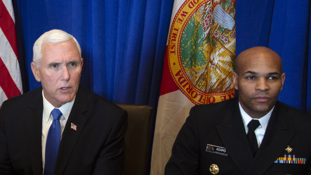 US Vice President Mike Pence, left, speaks while Vice Admiral Jerome Adams, US Surgeon General, looks on.
