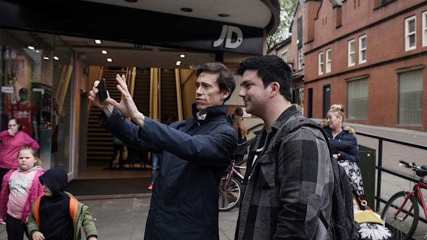 Rory Stewart, center, a candidate for prime minister, takes a selfie with a supporter as he campaigns in Wigan, England.