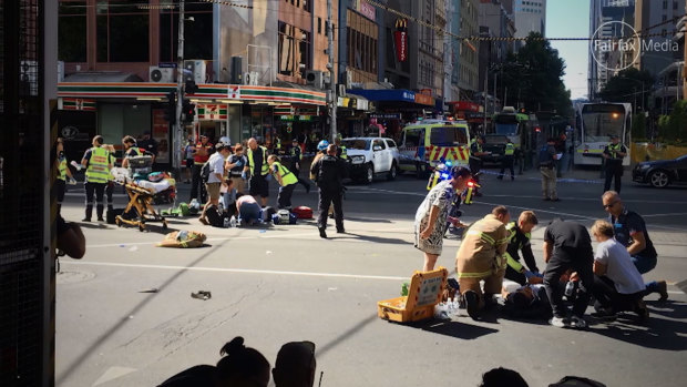Emergency services tend to the wounded at the intersection of Elizabeth and Flinders streets on December 21, 2017.