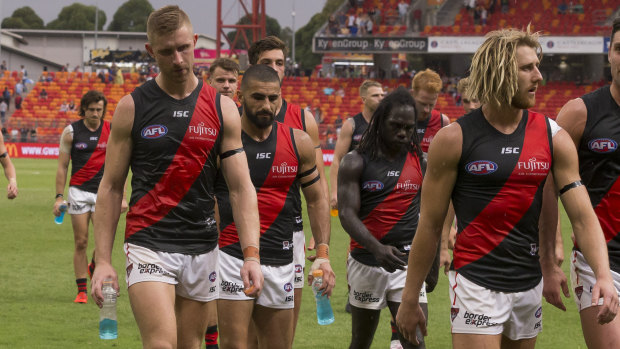 Dyson Heppell (right) leads the defeated Bombers from the field.