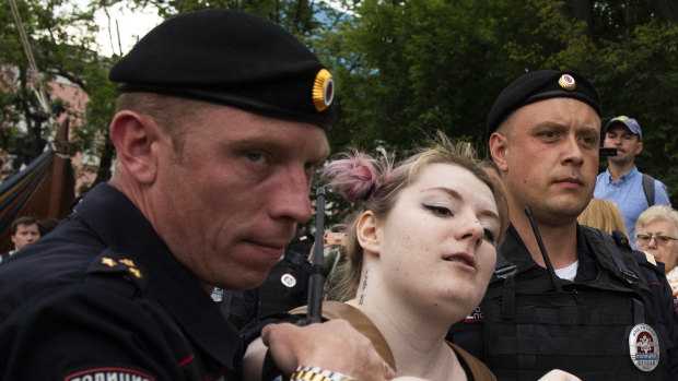 Police officers detain a woman during a march in Moscow, Russia.