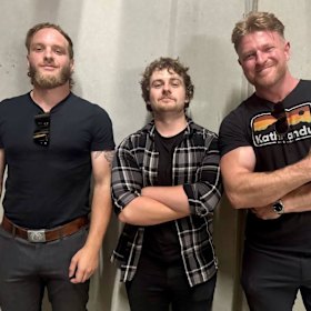 Heckler Laurence McIntyre poses with extreme right figures Joel Davis and Blair Cottrell.