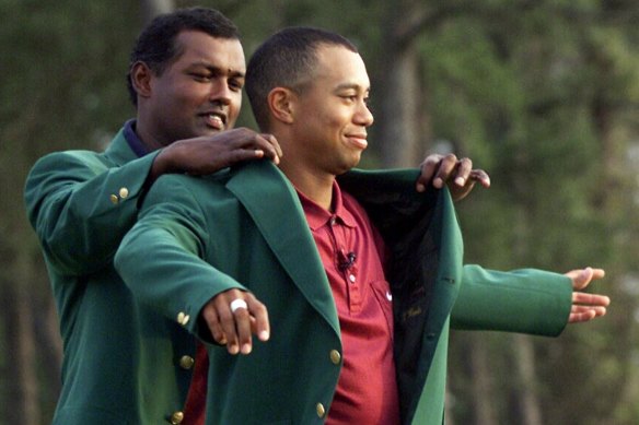 Woods receives his green jacket from Vijay Singh following his 2001 win.