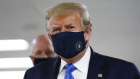 President Donald Trump wears a mask as he walks down the hallway during his visit to Walter Reed National Military Medical Centre.