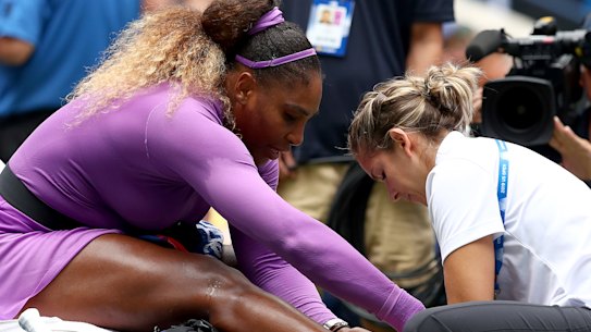 Serena Williams receives treatment after rolling her ankle.