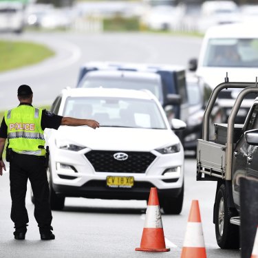 Vehicles arriving from NSW queue at a police checkpoint at the Queensland-NSW border in Coolangatta.