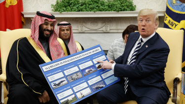 US President Donald Trump shows a chart highlighting arms sales to Saudi Arabia during a meeting with Saudi Crown Prince Mohammed bin Salman in the Oval Office of the White House in Washington in March, 2018.