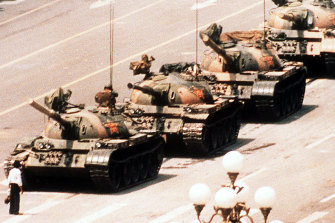 A lone protester clutching a shopping bag prevents a line of tanks from reaching Tiananmen Square, Beijing on June 4, 1989.