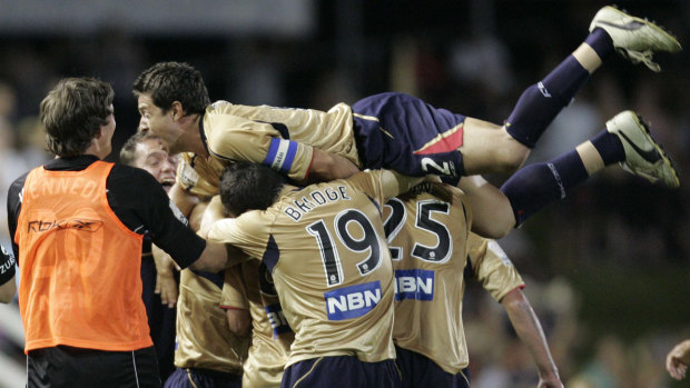 Jets captain Paul Okon swamps his teammates after another goal against Victory in 2007. 