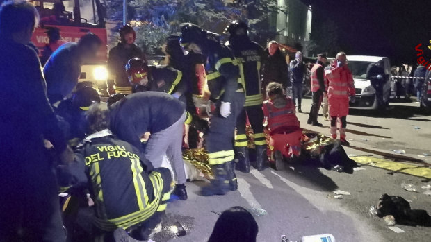 Rescuers assist injured people after the nightclub stampede.