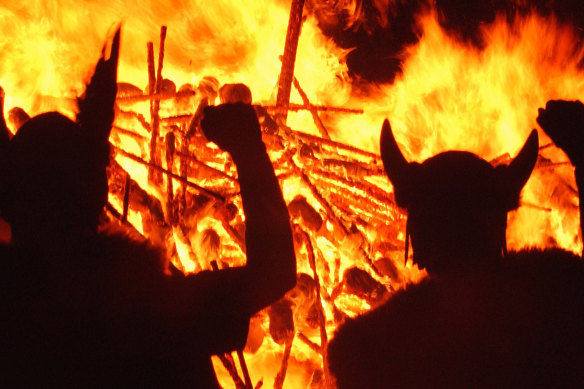 Locals dressed as Vikings silhouette in front of a burning Viking galley in Lerwick, Shetland, Scotland.
