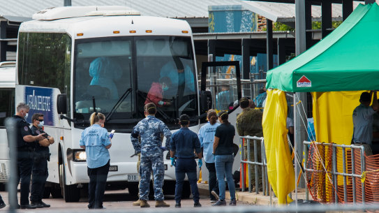 Multiple government agencies gather beside buses to take Australian evacuees from the coronavirus-struck cruise ship Diamond Princess after they arrived on a Qantas flight from Japan at Darwin International Airport on February 20.