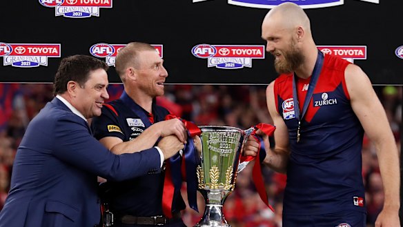 Garry Lyon presents the premiership cup to Simon Goodwin and Max Gawn.