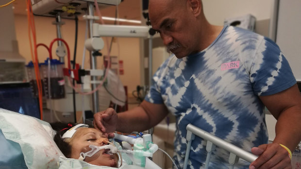 Fuzzy Maiava at the bedside of his youngest daughter, Apolonia, who was hit by a speeding motorist on October 7 last year, the 10-year anniversary of Qantas Flight 72.