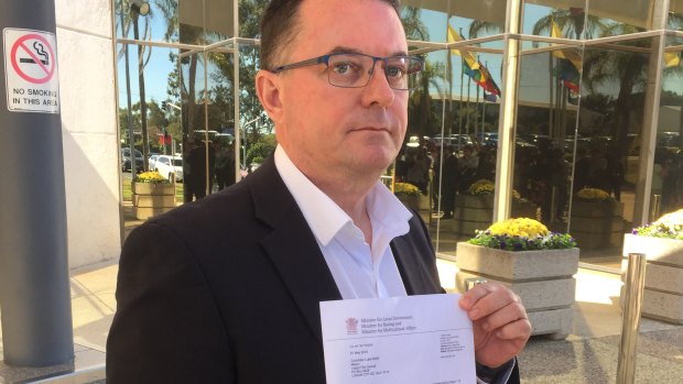Logan mayor Luke Smith with the letter from Local Government Minister Stirling Hinchliffe, which formally suspended him.