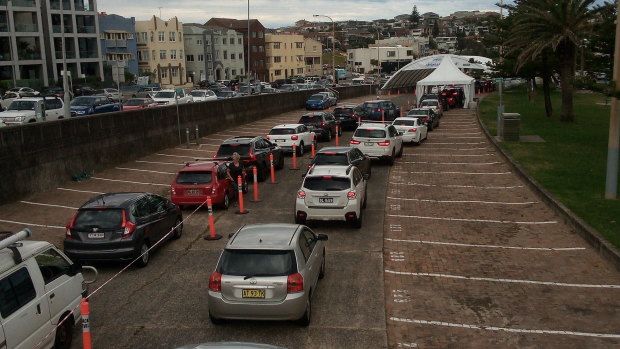 Cars queue up in the car park and the street at the Bondi Beach COVID testing centre on Friday.