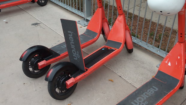 An unlocked Neuron scooter with the battery exposed.