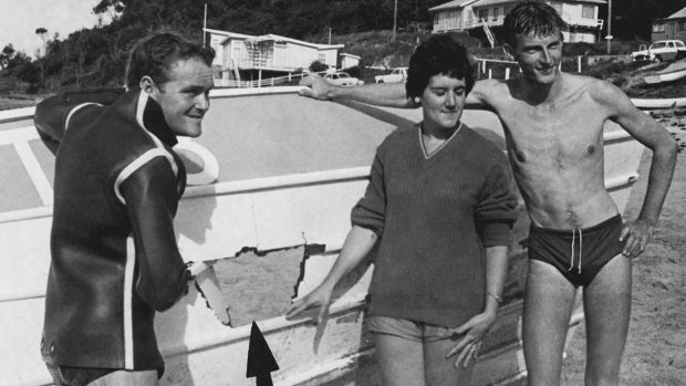 Neville Hopkins, Carolyn Hayes and Ernest Thring with the damaged boat. Arrow points to hole ripped in bottom. 