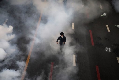 An anti-government protester runs from a cloud of tear gas during demonstrations in Bangkok on Saturday.
