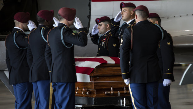 A US Army carry team moves the transfer case containing the remains of Army Spc Michael Nance in Chicago. Two more US members have been killed since Nace died in late July. 