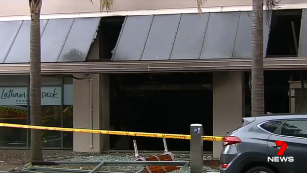 Glass is left shattered on the ground outside a shop beneath an apartment block following the explosion.