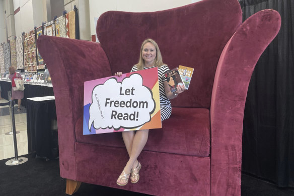 School librarian Jamie Gregory displays two books that have been repeatedly challenged in the US, while seated at the Banned Books from the Big Chair station at the ALA conference in Chicago on June 24.