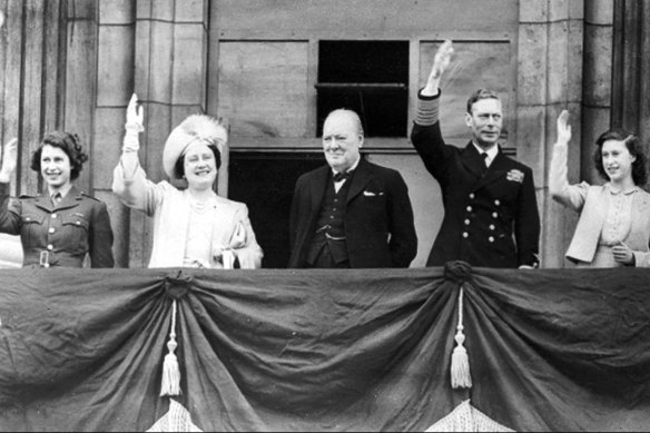 Prime Minister Winston Churchill looks on, as King George VI, Queen Elizabeth (later Queen Mother), Princess Elizabeth, left, and Princess Margaret, right, wave to crowds from the balcony of Buckingham Palace on VE Day, May 8, 1945.