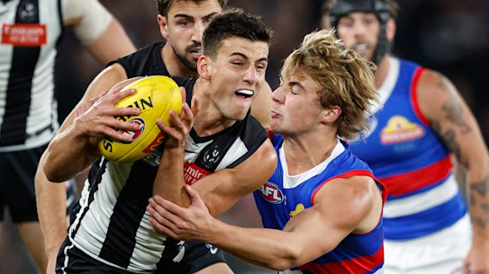 Nick Daicos is tackled by Western Bulldogs’ Ryley Sanders.