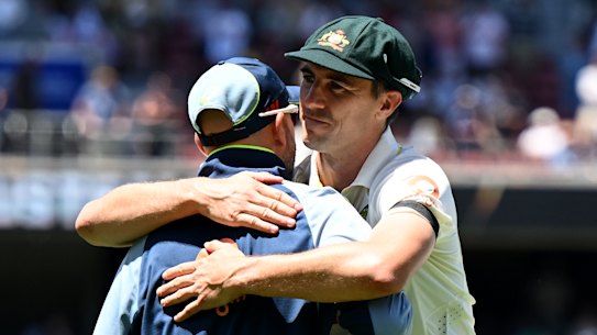 Pat Cummins hugs injured teammate Nathan Lyon while Travis Head waits to do the same after Australia’s win in the third Ashes Test in Adelaide.