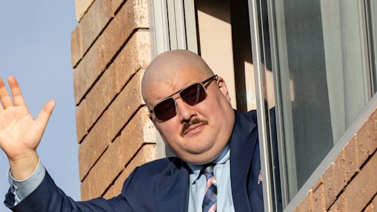 Simeon Boikov waves from the Russian consulate in Sydney in April 2023. He remains in a self-imposed exile after breaching the suppression on Rosentool’s name, and assaulting a Ukraine supporter.