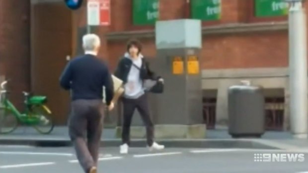 A man armed with a chair confronts Mert Ney as he runs through the streets.