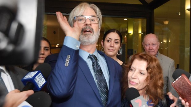 An animated John Jarratt celebrates his not guilty verdict on Friday, alongside his wife Rosa Miano.