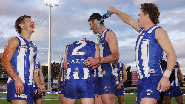 Will Phillips, Jaidyn Stephenson, and Tristan Xerri of the Kangaroos receive a Powerade shower from Cameron Zurhaar after a win against the Gold Suns at Blundstone Arena.