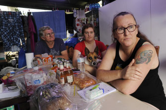 Rita and Johan Spek, with their daugher Kaitlind (centre), are eager to leave their home in South Lismore after it was flooded in February. They are living under an outdoor awning and sleeping in a van.