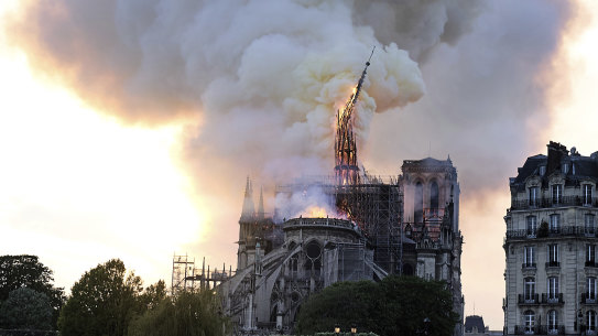 Flames and smoke rise as the spire on Notre Dame cathedral collapses.