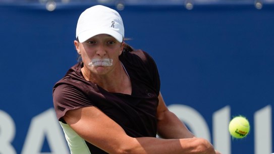 Iga Swiatek trains wearing tape over her mouth.