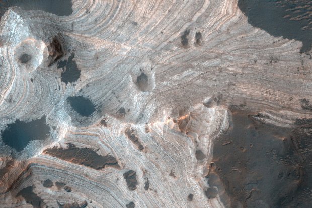 Much of Mars is covered by sand and dust but in some places, such as Holden Crater, stacks of sedimentary layers are visible.