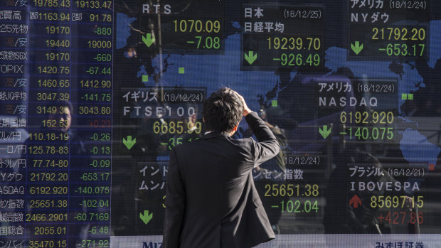 A man looks at an electronic stock board outside a securities firm in Tokyo. The Nikkei 225 index entered bear market territory, as Japanese stocks headed for their worst December on record. 