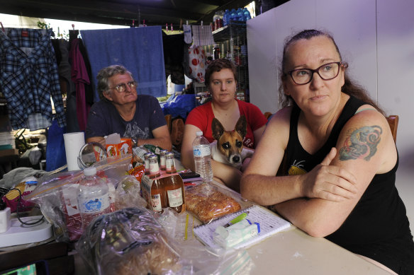 Rita and Johan Spek, with their daugher Kaitlind (centre), are eager to leave their home in South Lismore after it was flooded in February. They are living under an outdoor awning and sleeping in a van. 